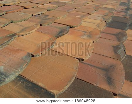 Old clay shingles lying on the roof for a background