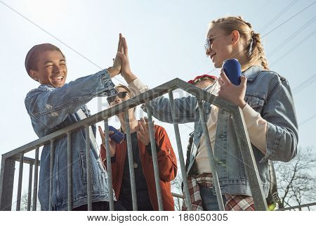 Teenagers Having Fun And Giving Highfive In Skateboard Park, Hipster Style Concept