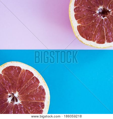 Cut in half a grapefruit on a pink and blue background