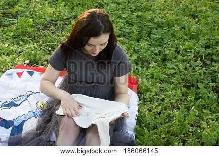 Happy young pregnant woman playing with baby sweater. slowmotion