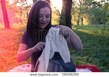 Happy young pregnant woman playing with baby sweater. slowmotion