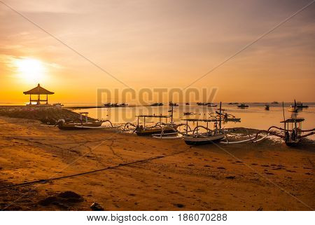 Traditional Balinese Boats And Pavilion In Sanur Beach In The Morning At Dawn, Bali, Indonesia.