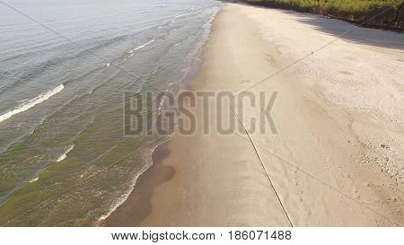 Aerial view of Baltic sea shore, waves and sandy beach. Lubiatowo, Poland