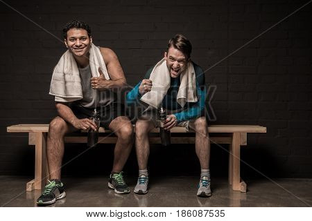 Handsome Young Athletes Resting At Gym Locker Room