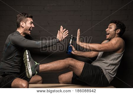 Handsome Male Athletes Resting And Conversing At Gym Locker Room