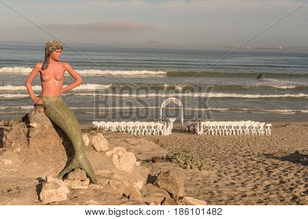 LANGEBAAN SOUTH AFRICA - APRIL 1 2017: Preparations for a wedding under the watchful eyes of a mermaid on the beach at Boesmanland Plaaskombuis in Langebaan in the Western Cape Province