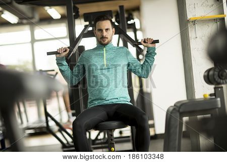 Young Man Doing Exercise For Triceps In The Gym On Mashine
