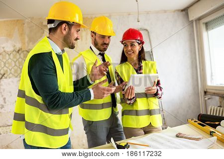 Group Of Young Arhitects Withl Tablet On Construction Site