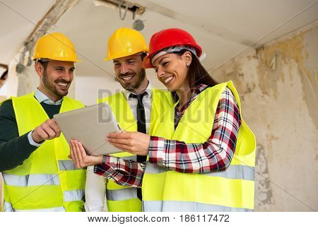 Group Of Young Arhitects With L Tablet On Construction Site