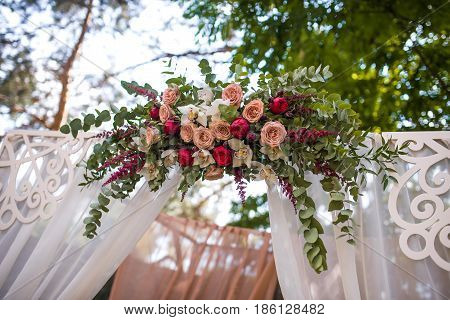 Beautiful Wedding Ceremony Outdoors. Decorated Chairs Stand On The Grass. Wedding Arch Made  Flowers