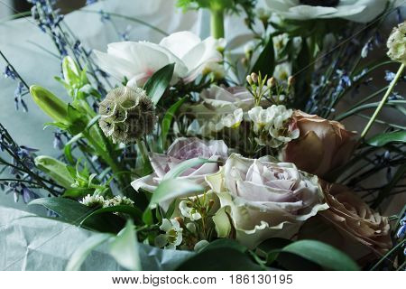 Flower arrangement with branches of a pistachio branches of Ruscus, carnations, roses, branch of Brunei, berries of Hypericum. Wedding concept