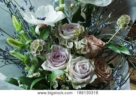 Flower arrangement with branches of a pistachio branches of Ruscus, carnations, roses, branch of Brunei, berries of Hypericum. Wedding concept