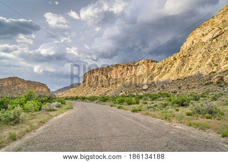 Thompson Canyon road through Book Cliffs in eastern Utah with heavy storm clouds