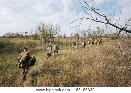 Dyatlovichi, Belarus - October 1, 2016: Reenactors Dressed As Russian Soviet Red Army Soldiers Of World War II Walking With With Maxim's Machine Gun Weapon In Autumn Meadow At Historical Reenactment
