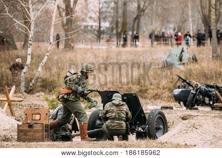 Gomel, Belarus - November 26, 2016: Re-enactors Dressed As German Soldiers In WWII Load A Cannon Shells At Firing Position. Celebration Of 73rd Anniversary Of Liberation Of Gomel From Nazi Invaders