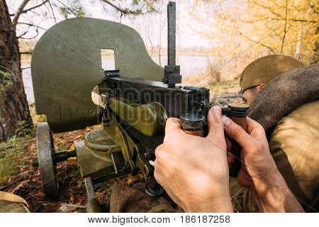 Reenactors Dressed As Russian Soviet Red Army Soldiers Of World War II Hidden Sitting With Machine Gun Weapon In An Ambush In Autumn Forest