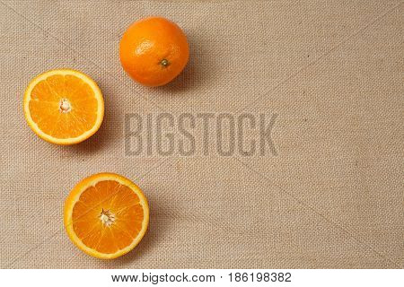 Fresh Orange lying on a sackcloth surface.