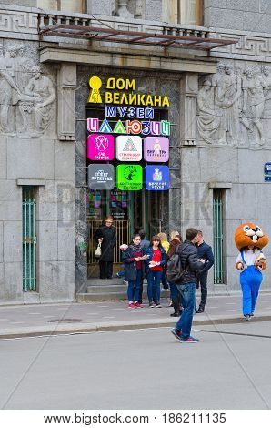 SAINT PETERSBURG RUSSIA - MAY 1 2017: Unknown people are walking along Bolshaya Morskaya Street near famous House of Giant (Museum of Illusions). Building also houses Garden of Butterflies Glass labyrinth contact zoo and other entertainment