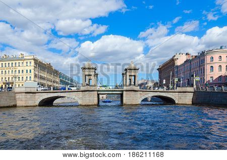 SAINT PETERSBURG RUSSIA - MAY 3 2017: Excursion ship on Fontanka River near Lomonosov Bridge in St. Petersburg. Unidentified people are visiting sights during walk along rivers and canals of city