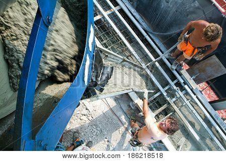 Truck Operator Pouring Cement Into Crane Bucket