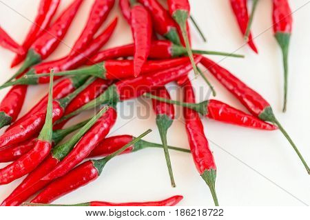 red hot chili peppers, popular spices concept - placer of beautiful red hot chili peppers, pods freely scattered on white background, top view, flat lay, isolated