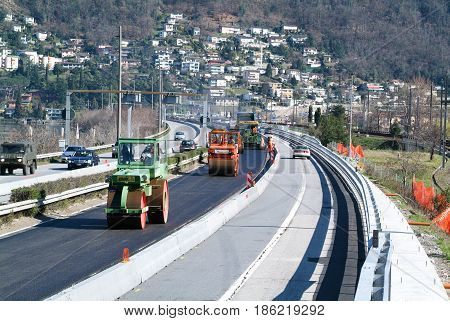Workers And Vehicles During The Asphalting Of The Highway