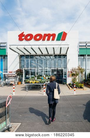 FRANKFURT GERMANY - APR 1 2017: Woman walking to the entrance of TOOM the German DIY-store chain offering home improvement and do-it-yourself goods - customers buying goods selecting the best tools