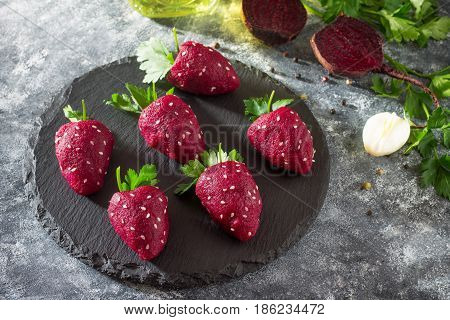Vegan Strawberry Snack Of Boiled Beets Stuffed With Herring On A Slate Board. Healthy Eating Concept