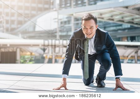 Happy confident Asian businessman ready to start his career or business with city in background. Business start concept.
