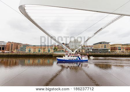 Boat Passing Under Tilted Millennium Bridge In Newcastle, Uk