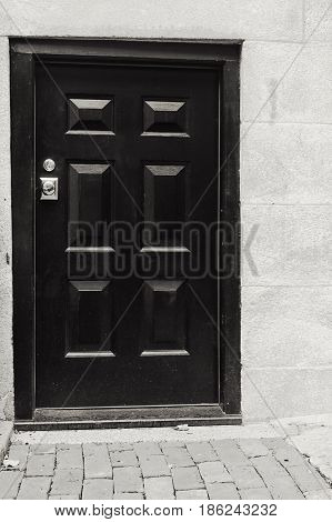 A black and white photo of a tall door.