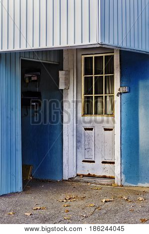 Outside door with curtains on a blue wall.