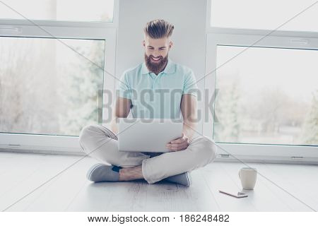 Cheerful Student Is Studying With His Laptop Sitting On The Floor At Home. He Feels Relaxed And Happ
