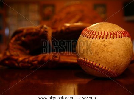 Close-up de uma bola de beisebol com uma luva por trás dele.