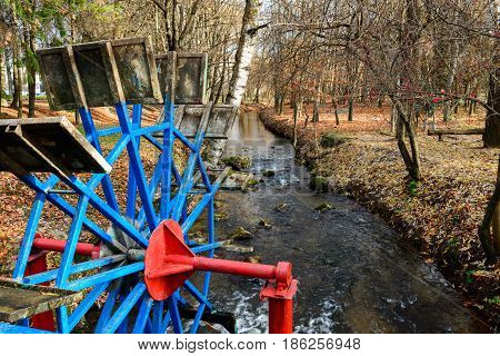 Metallic Wheel Watermill In A Park
