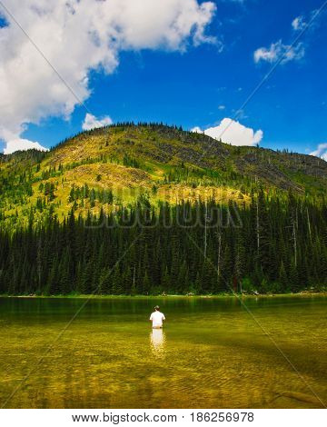 Man fishing at Moose Lake in Whitefish Range near Kalispell, Montana