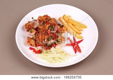Thai spicy recipe Spicy crispy deep-fried Karaoge chicken salad call Yum Kai Zap in Thai topped sliced cabbage french fried strick and red chili.