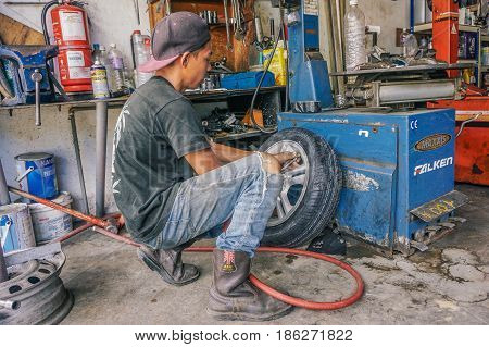 Labuan,Malaysia-May 9,2017:Car tire service mechanic changing car wheel before makes computer wheel balancing on special equipment machine tool in auto repair service in Labuan,Malaysia.
