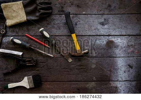 Inverted welding machine welding equipment on a wooden desk with workshop background welding mask leather gloves welding electrodes high-voltage wires with clips set of accessories for arc welding.
