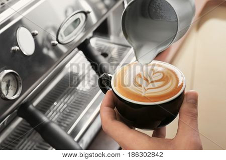Man drawing on coffee with frothed milk