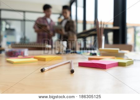 Pencil And Sticky Note On Table With Background Of Young University Students Studying With Tablet Do