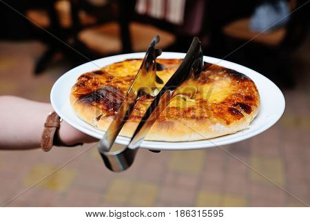 Georgian khachapuri with cheese. waiter brings a plate on a national Georgian dish - khachapuri