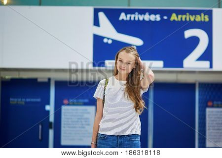 Beautiful Young Tourist Girl With Backpack And Carry On Luggage In International Airport