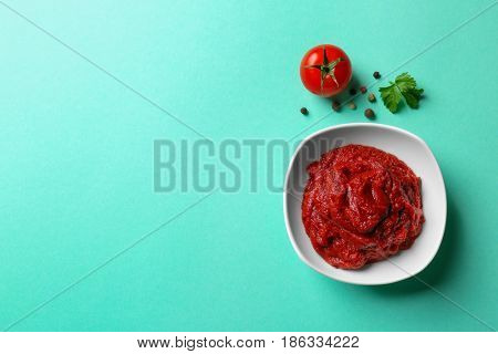 Delicious tomato paste in bowl on color background, closeup