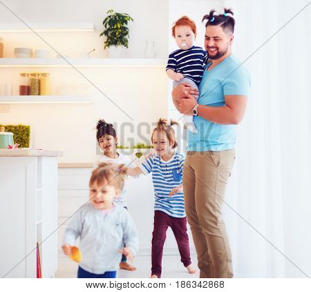 father with weird hairstyle looking after mad kids at home