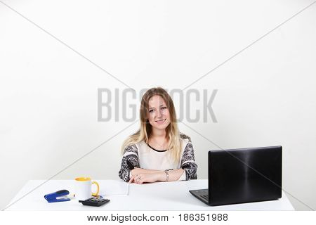 The girl sitting behind a desk in the Office. One on-white background
