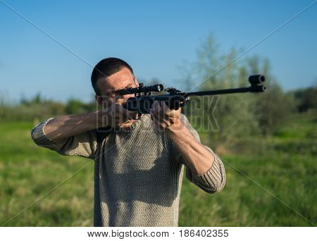 The man takes aim at the target with a sniper strikeball rifle. Selective Focus