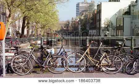 Green tranportation of Amsterdam Netherland. Bikes parking over canal bridge