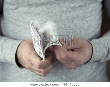 Hands counting dollars. Selective focus. Shallow DOF