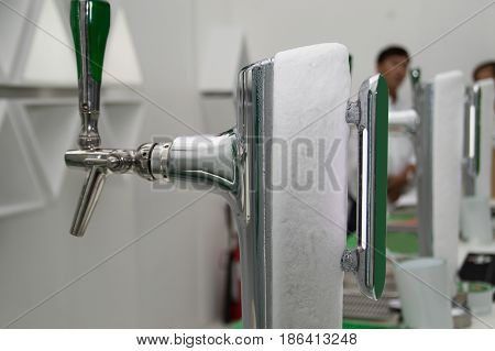 Pouring fresh beer. Close-up of pouring beer while standing at the bar counter